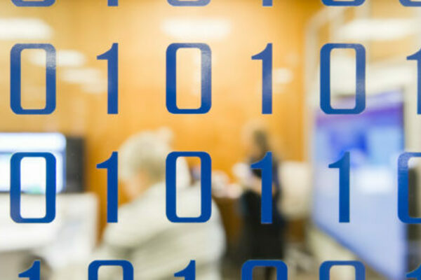 Binary code on a clear glass wall looking into a meeting room.