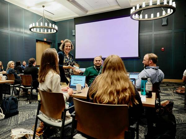 Group picture of Vickie Woodard speaking with a group of Data Science students at Immersion.