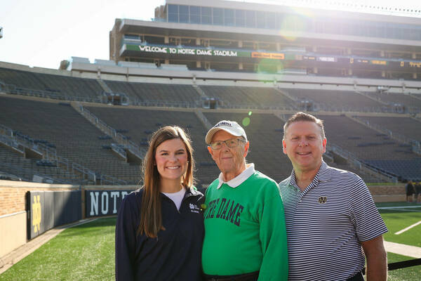 Maggie Rose and her family poses for a group picture on the field of the stadium.