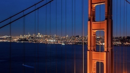 The Golden Gate Bridge with the lights of San Francisco in the background.